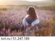 Lavender Woman Flowers: Smiling girl holds flowers in lavender field during sunny day, enjoying the fragrance. Стоковое фото, фотограф svetograph / Фотобанк Лори