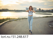 Young beautiful caucasian blonde girl listening to music with smartphone walking and dance in the city with headphones smiling - relax, youth, emancipation concept. Стоковое фото, фотограф Арзюков Вадим Николаевич / Фотобанк Лори