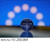 CR2032 Lithium Battery Close-Up with Blue Background. Редакционное фото, фотограф Sergakoff / Фотобанк Лори