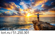 Man Embraces Sunrise on a Rugged Clifftop. Generative AI. Стоковое AI-изображение, AI-художник Roman Zavorotny / Фотобанк Лори