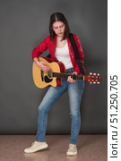 Young woman guitarist playing six string acoustic guitar, standing full length on stage. Стоковое фото, фотограф А. А. Пирагис / Фотобанк Лори