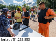 Сотрудница полиции в форме демонстрирует спецсредства на мероприятии в парке. Редакционное фото, фотограф Кирилл Сиротюк / Фотобанк Лори