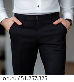 Close-up of formal attire showcasing a black dress shirt and slacks. Стоковое AI-изображение, AI-художник Katsiaryna Repich / Фотобанк Лори