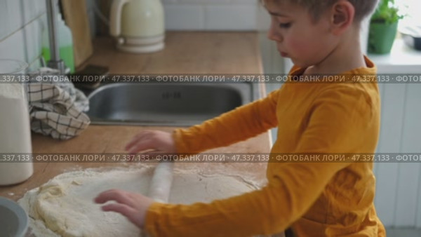 6 years old boy cooking pizza in the kitchen. Child rolling up the dough, adding cheese, tomatoes and smear sauce the base. Preschool kid making homemade pizza. Cooking class, culinary. Little baker. Стоковое видео, видеограф Марина Демидюк / Фотобанк Лори