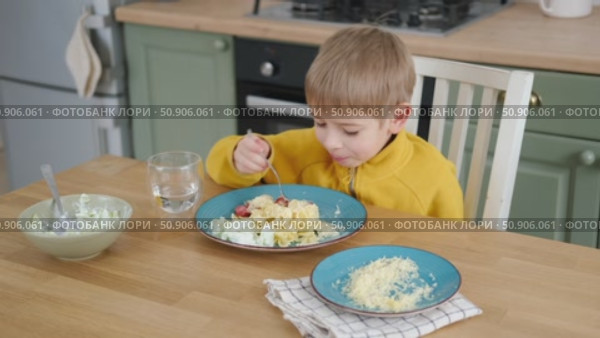 6 years old boy eats pasta with cheese from blue plate. Child is eating spaghetti. Lunch time. Good appetite. Tasty children food. Close-up portrait. Carbs dinner. Fast food. Kid eating with fork. Стоковое видео, видеограф Марина Демидюк / Фотобанк Лори