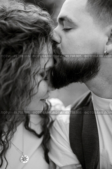 a bearded groom plays a stringed instrument and a girl with green hair sits in a spring meadow. Стоковое фото, агентство Ingram Publishing / Фотобанк Лори