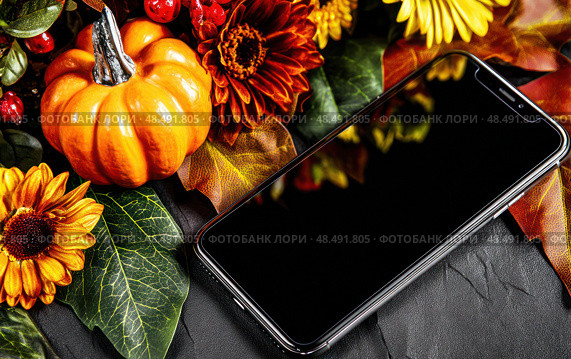 A black iPhone is on a table with a bunch of fall flowers. Стоковое AI-изображение, AI-художник Ярославский Максим / Фотобанк Лори