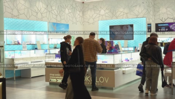 A Bustling Jewelry Store Scene Captured in Two Frames, Featuring Customers Engaging with Staff Amidst Elegant Displays of Sparkling Accessories and Unique Designs. Стоковое видео, видеограф Владимир Федоров / Фотобанк Лори