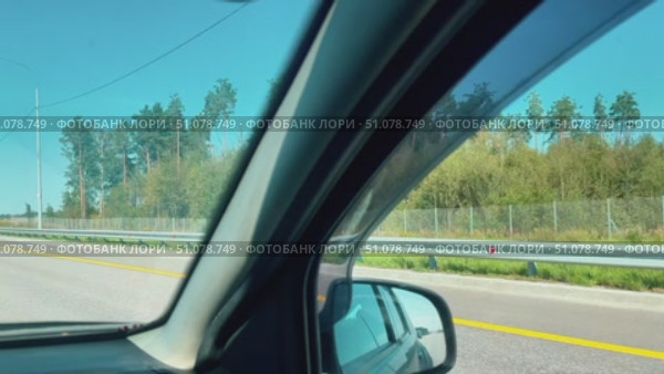 A car window is shown with a clear view of the road. Стоковое видео, видеограф Ярославский Максим / Фотобанк Лори