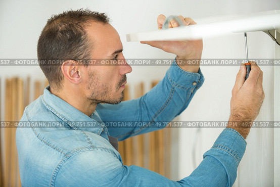 a carpenter screwing a furniture. Стоковое фото, агентство Ingram Publishing / Фотобанк Лори