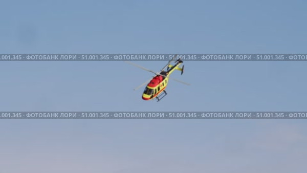 A close-up of a bright yellow-red helicopter with medical symbols, flying fast against the sky, responding to an urgent call. Стоковое видео, видеограф Strunov David / Фотобанк Лори