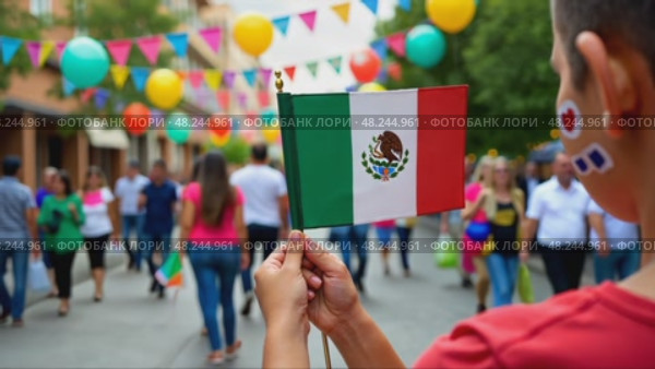 A close-up of a child's hands holding a small Mexican flag, their face painted with traditional designs. The scene is set in a bright street. Стоковое AI-видео, аниматор Sergey Grishin / Фотобанк Лори
