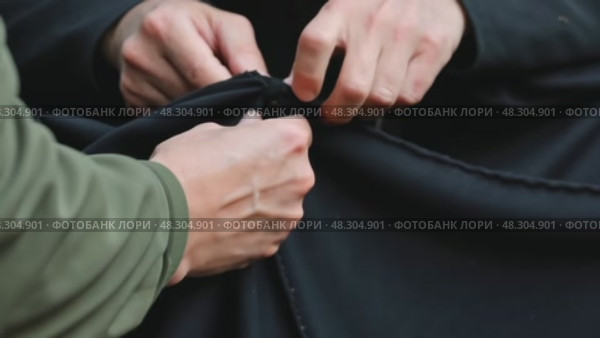 A close-up of a woman hands sewing a black cloth banner, her fingers trembling slightly as she prepares for the Ashura procession. Стоковое AI-видео, аниматор Sergey Grishin / Фотобанк Лори