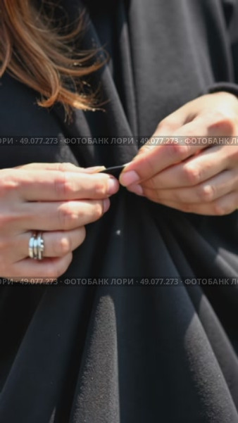 A close-up of a woman hands sewing a black cloth banner, her fingers trembling slightly as she prepares for the Ashura procession. Стоковое AI-видео, аниматор Sergey Grishin / Фотобанк Лори