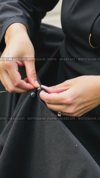 A close-up of a woman's hands sewing a black cloth banner, her fingers trembling slightly as she prepares for the Ashura process. Стоковое AI-видео, аниматор Sergey Grishin / Фотобанк Лори