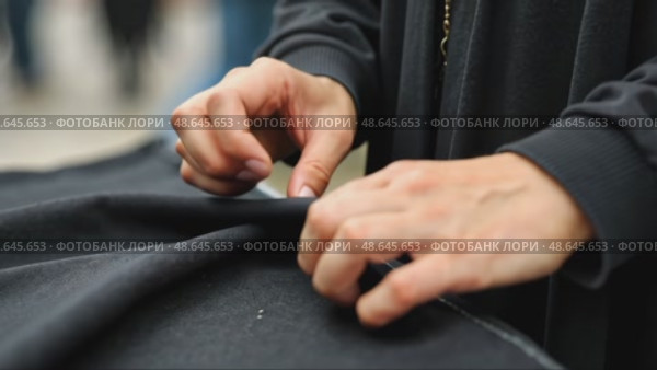 A close-up of a woman's hands sewing a black cloth banner, her fingers trembling slightly as she prepares for the Ashura process. Стоковое AI-видео, аниматор Sergey Grishin / Фотобанк Лори