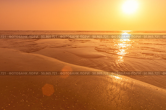 A colorful sunset or sunrise on the seaside with a sandy beach with impurities of volcanic ash. Mandrem, Goa, India. (2018 год). Стоковое фото, фотограф Емельянов Евгений Викторович / Фотобанк Лори