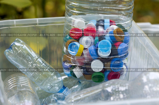 A container made of plastic bottles and plastic lids. Garbage collection around the world. Clean the planet of plastic garbage. Ecology. Sorting garbage. Стоковое фото, фотограф Photojuli / Фотобанк Лори