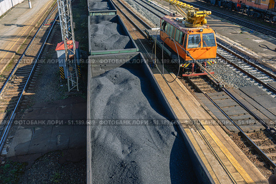 A crane on a small railway locomotive for the repair of railway tracks. Repair equipment on the railway. Freight wagons filled with coal. Transportation of industrial raw materials by rail. Стоковое фото, фотограф Эдуард Белкин / Фотобанк Лори
