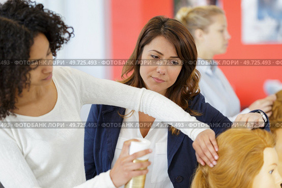 a female apprentice using hairspray. Стоковое фото, агентство Ingram Publishing / Фотобанк Лори