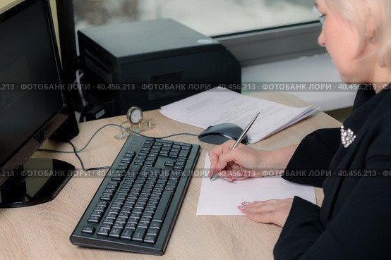 A female director working in an office is sitting at a table, analyzing business statistics, checking documents. Стоковое фото, фотограф Юрий Поздников / Фотобанк Лори