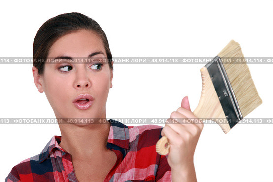 A female painter looking at a brush with a dubious look. Стоковое фото, агентство Ingram Publishing / Фотобанк Лори