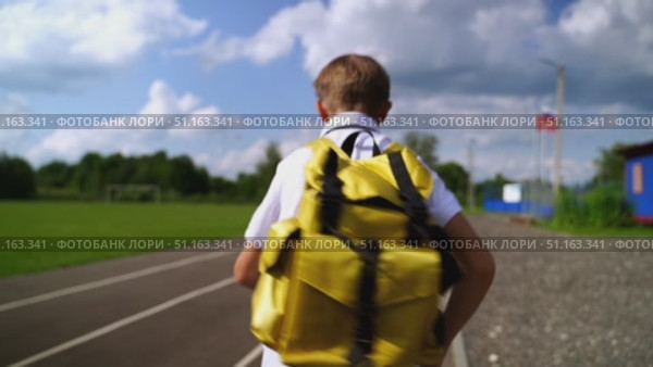 A first-grader boy goes to school with a backpack. Стоковое видео, видеограф Igor Skripachev / Фотобанк Лори