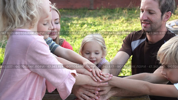A friendly family joins their hands as a sign of joint success. Стоковое фото, фотограф Mikhail Davidovich / Фотобанк Лори