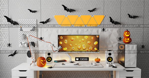 A general view of a gamer's home workplace with a computer and a gamepad decorated with decorations for the Halloween holiday. Стоковое фото, фотограф Енваев Андрей / Фотобанк Лори