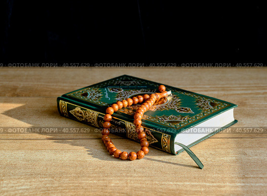 A green and gilded book of Quran and a rosary. Стоковое фото, фотограф Ирина Кононова / Фотобанк Лори