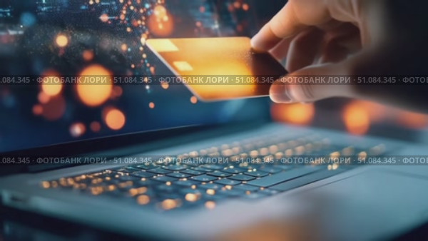 A hand holding a credit card above a laptop keyboard. The scene illustrates online shopping and digital transactions with glowing lights in the background. Стоковое AI-видео, аниматор Nart / Фотобанк Лори