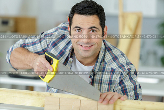 a happy carpenter holding planks. Стоковое фото, агентство Ingram Publishing / Фотобанк Лори