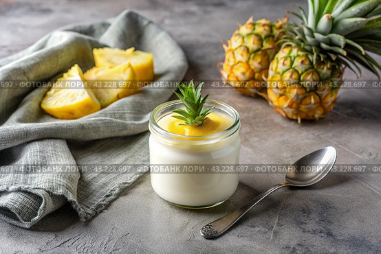 A healthy, healthy breakfast. Homemade pineapple yogurt with fresh pineapples, vintage spoon and towel on a stylish gray background. Стоковое AI-изображение, AI-художник Photojuli / Фотобанк Лори