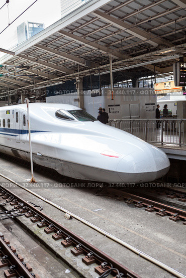 A JR West N700 series high speed train stands on Tokyo station on the Tokaido Shinkansen line. It is Nozomi bullet train which stop at only the largest stations.. Токио, Япония (2013 год). Редакционное фото, фотограф Кекяляйнен Андрей / Фотобанк Лори