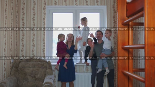 A large and friendly family at the window during quarantine and waved. Стоковое видео, видеограф Mikhail Davidovich / Фотобанк Лори