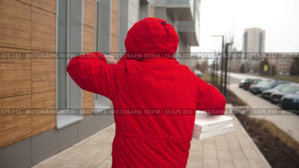 A man courier in red clothes delivering pizza - looking at the watch and running to the door. Стоковое видео, видеограф Константин Шишкин / Фотобанк Лори