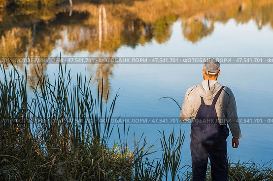 A man fishing on a warm autumn day on a pond. Стоковое фото, фотограф Photojuli / Фотобанк Лори