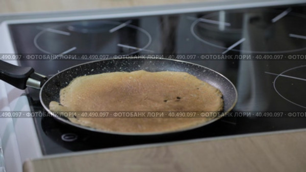 A man flips a pancake with his hands in a frying pan. Стоковое видео, видеограф Юрий Поздников / Фотобанк Лори