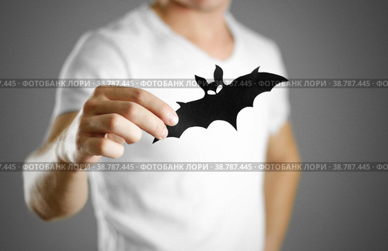 A man in a white t-shirt holds a black silhouette of a bat. Close up. Стоковое фото, фотограф Плотников Дмитрий / Фотобанк Лори