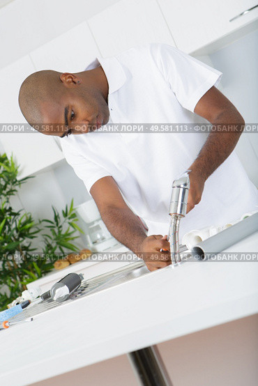 a man is fixing the tap. Стоковое фото, агентство Ingram Publishing / Фотобанк Лори