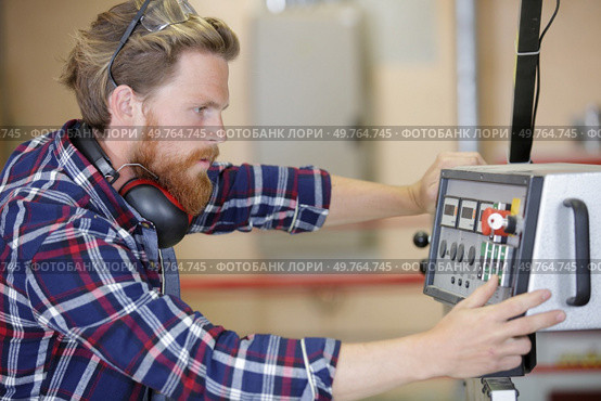 a man is operating machine. Стоковое фото, агентство Ingram Publishing / Фотобанк Лори