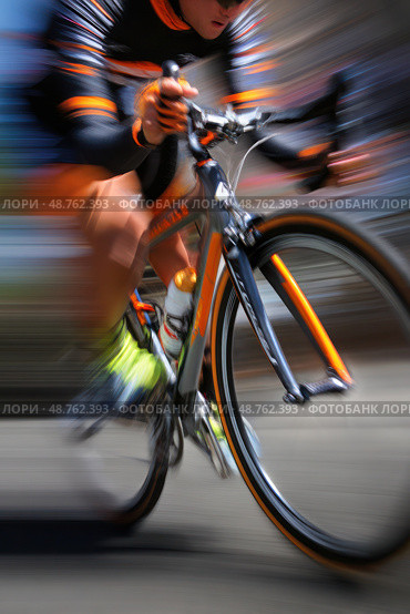A man is riding a bicycle with orange and black stripes. Стоковое AI-изображение, AI-художник Ярославский Максим / Фотобанк Лори