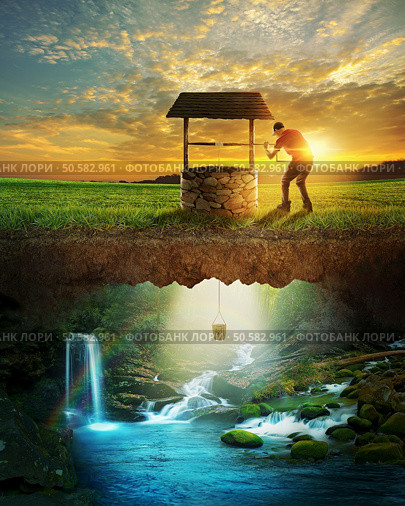 A man lowers a bucket from a well into clear water. Стоковое фото, агентство Ingram Publishing / Фотобанк Лори