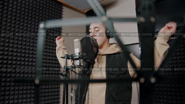 A man rapper recording his track in the studio actively gestures while the recording. Стоковое видео, видеограф Константин Шишкин / Фотобанк Лори