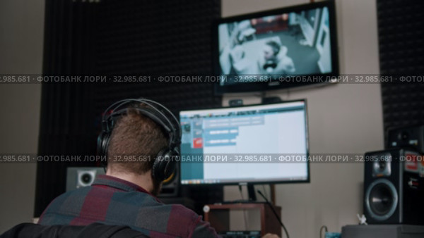 A man sound engineer watching the rapper whlie recording his track. Стоковое видео, видеограф Константин Шишкин / Фотобанк Лори