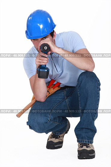 A man using his drill as a gun. Стоковое фото, агентство Ingram Publishing / Фотобанк Лори
