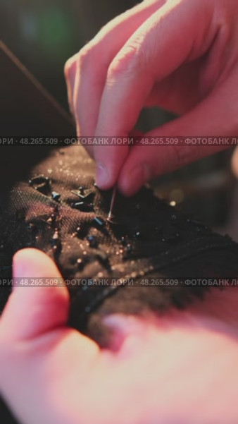 A master sews national Arab clothes abay with a needle and thread in his atelier. Стоковое видео, видеограф Aleksey Kidisyuk / Фотобанк Лори