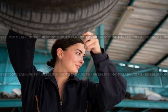 A mechanic for automobiles examining the condition of tires that have been in use for some time. Стоковое фото, агентство Ingram Publishing / Фотобанк Лори