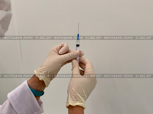 A medical officer in a white coat holds a syringe. Vaccination. Стоковое фото, фотограф Соболева Наталия / Фотобанк Лори