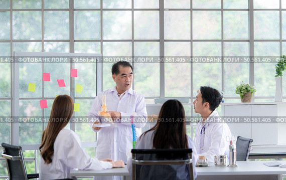 A medical professor is lecturing on a case study related to disease treatment to medical students. Стоковое фото, агентство Ingram Publishing / Фотобанк Лори